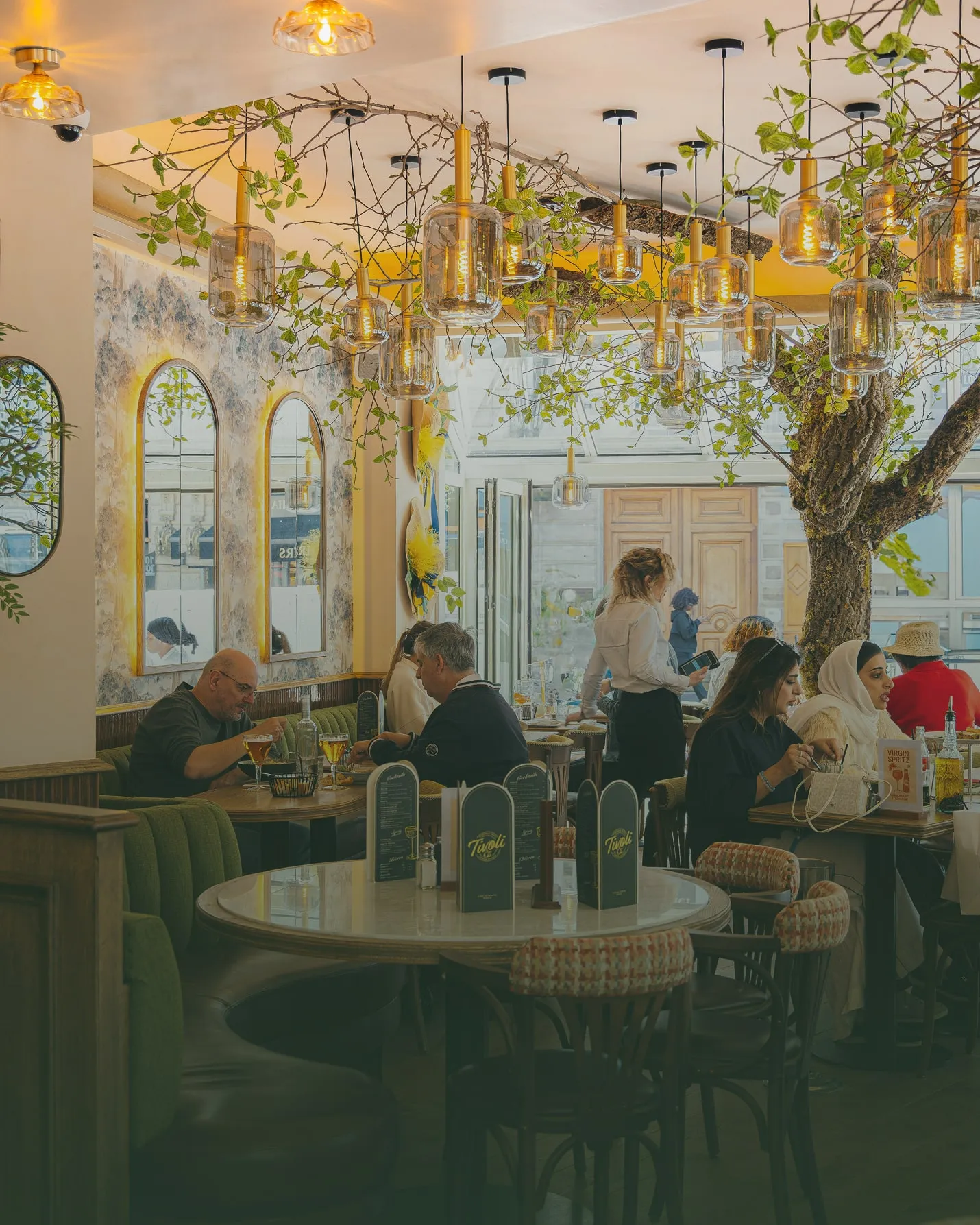 Salle intérieure lumineuse du restaurant Tivoli avec décoration végétale